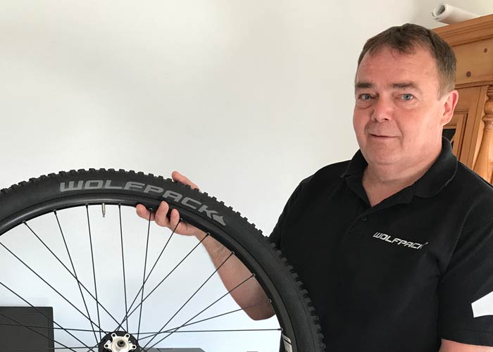 Wolfgang wearing a black shirt and holding a tire